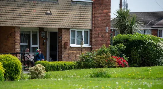 Two tenants standing outside at the front of their home.png