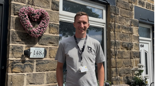 A plumber from Berneslai Homes standing in front of a home.