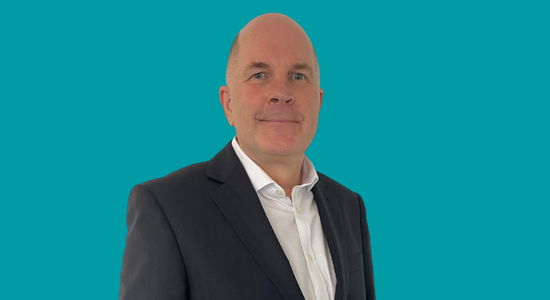 White text on a blue background, which says 'Ken Taylor, Chair of the Board.' There is also an image of Ken Taylor to the left of the text.